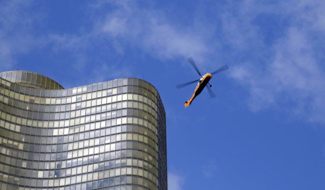 A heavy-duty helicopter arriving on scene in downtown Chicago to execute a massive commercial HVAC rooftop boiler lift and mechanical rigging project at Lake Point Tower.