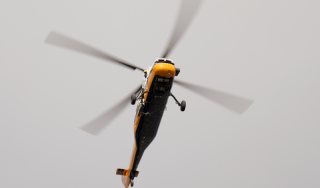 Chicago Commercial HVAC - Helicopter Rigging Descent A heavy-duty helicopter descends back toward a secured downtown staging area to rig the next high-efficiency commercial boiler for the massive rooftop HVAC upgrade at Lake Point Tower.