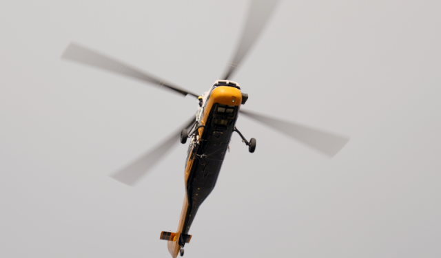 A heavy-duty helicopter descends back toward a secured downtown staging area to rig the next high-efficiency commercial boiler for the massive rooftop HVAC upgrade at Lake Point Tower.