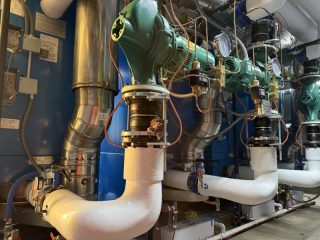 Chicago Commercial HVAC - Taco In-Line Boiler Pumps A close-up view of heavy-duty, green Taco in-line water pumps and piping installed to circulate hot water for the new commercial boilers at Lake Point Tower.