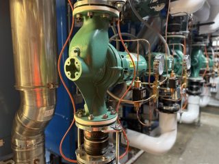 Chicago Commercial HVAC - Taco In-Line Boiler Pumps A close-up view of heavy-duty, green Taco in-line water pumps and piping installed to circulate hot water for the new commercial boilers at Lake Point Tower.