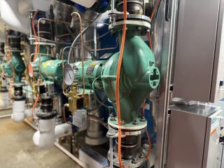 Chicago Commercial HVAC - Taco In-Line Boiler Pumps A close-up view of heavy-duty, green Taco in-line water pumps and piping installed to circulate hot water for the new commercial boilers at Lake Point Tower.