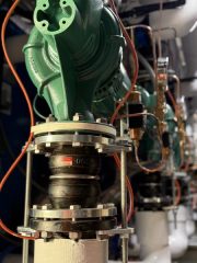 Chicago Commercial HVAC - Boiler Pump Expansion Joints A detailed close-up of heavy-duty rubber expansion joints and vibration isolators installed on the hydronic piping for the new commercial boiler pumps at Lake Point Tower.