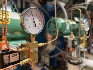 Chicago Commercial HVAC - Boiler Pump Pressure Gauges A detailed close-up of a pressure gauge and Penn control switch monitoring the hydronic piping on the newly installed Taco commercial boiler pumps at Lake Point Tower.