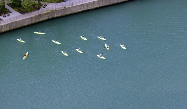 Top-down aerial view of kayaks navigating the Chicago waterway, demonstrating the active use of the city's marine and recreational infrastructure.