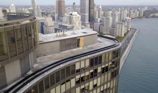 Chicago Commercial Infrastructure - High-Rise Mechanical Penthouse Close-up aerial view of Lake Point Tower's mechanical penthouse in Chicago, showcasing the structural rooftop infrastructure and exterior maintenance systems against the downtown skyline.