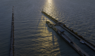 Chicago Municipal Infrastructure - Lake Michigan Breakwater Aerial High-angle aerial view of a concrete breakwater extending into Lake Michigan at sunrise, highlighting Chicago's coastal municipal infrastructure and engineering.
