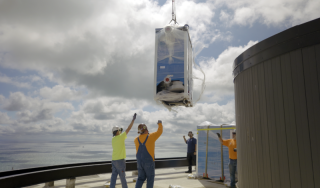 Chicago Commercial HVAC - Final Rooftop Boiler Rigging Temperature Service Company technicians guiding the final high-efficiency commercial boiler onto the rooftop of Lake Point Tower to successfully complete a massive Chicago HVAC helicopter lift.