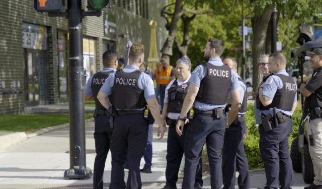 Chicago city police officers staging to close a major downtown intersection in preparation for a massive commercial HVAC helicopter lift and rooftop boiler rigging at Lake Point Tower.