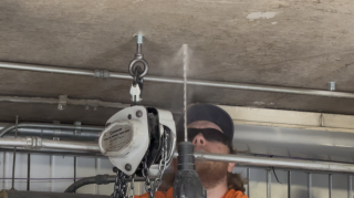 Commercial HVAC Rigging - Drilling Ceiling Eye-Bolts Commercial HVAC technician installing concrete ceiling anchors and chain hoist rigging for a major boiler replacement at Lake Point Tower.