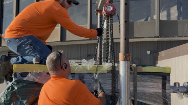 Commercial HVAC technicians executing a complex P-K boiler crane lift and rigging installation at Lake Point Tower.