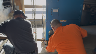 Commercial Boiler Installation - Machine Roller Rigging Commercial HVAC technicians executing indoor equipment rigging with a pry bar dolly and machine rollers for a boiler installation at Lake Point Tower.